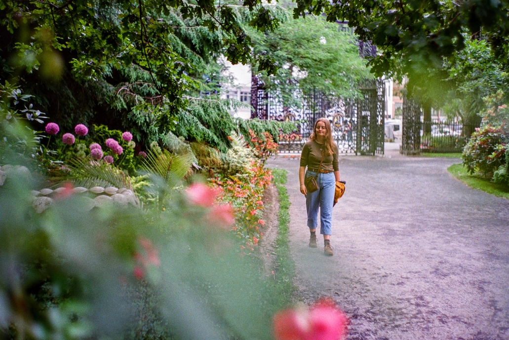 A picture of a girl waking through a garden